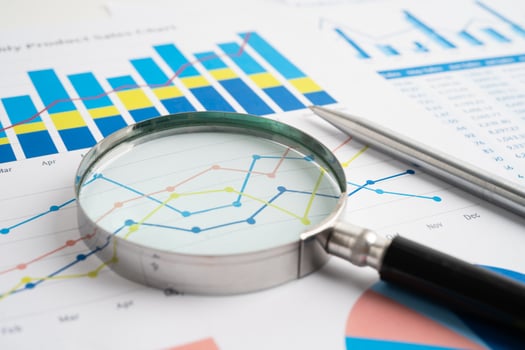 Magnifying glass on spreadsheet and graph paper. Financial economy photo