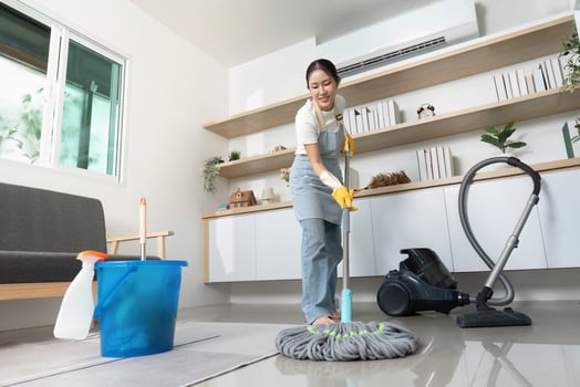 Home Cleaning. Woman mopping floor in modern living room with eco-friendly products. photo