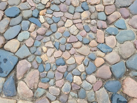 Old cobblestone pavement made of multicolored stones. Background Texture photo