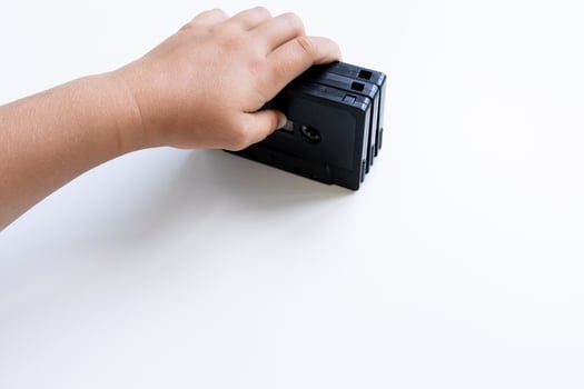 Child hand holding vintage vhs tape on white background photo