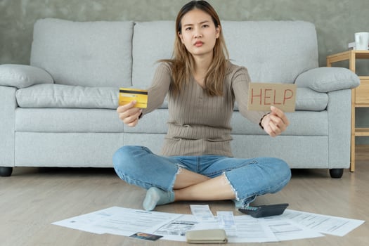 Stressed and headache asian woman with large bills or invoices no money to pay to expenses and credit card debt. shortage, Financial problems, mortgage, loan, bankruptcy, bankrupt poor. photo