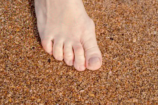 Close-up of bare foot on the beach. Relaxation and recreation on the seashore photo