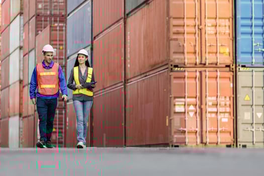 Logistics Professionals Walking Through Shipping Container Yard, Industrial Workers Inspecting Cargo at Port Terminal, Supply Chain Management Team in Intermodal Freight Depot photo