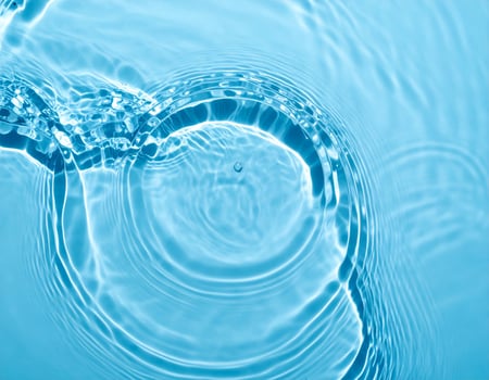 A turquoise-hued water surface featuring gentle ripples and waves in the background. photo