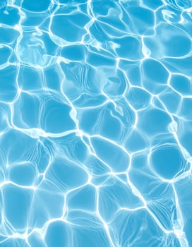 A background of turquoise-blue water with gentle ripples and waves photo