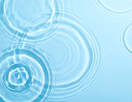 Background of gently rippling, light blue water with waves photo