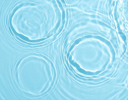 A tranquil blue-tinted water surface displaying gentle ripples and waves photo