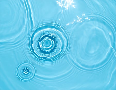 A serene background of turquoise-blue water with gentle ripples and waves photo