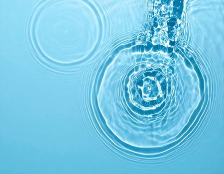 A soft turquoise surface featuring gentle ripples and flowing waves photo