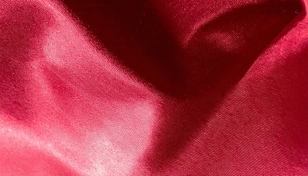 Close-up of a shining deep crimson silk fabric surface photo