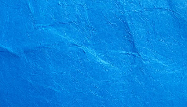 Close-up of a vibrant electric blue paper surface with textured pattern as background photo