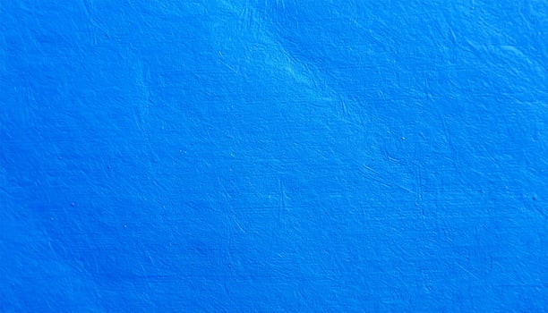 Close-up of a vibrant electric blue paper surface with a subtle textured pattern as the background photo