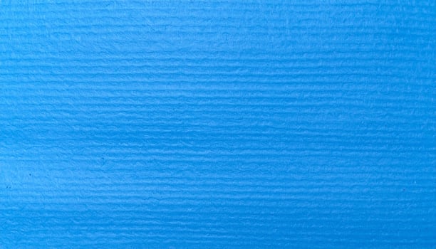 Close-up of a vibrant electric blue paper surface with a textured pattern in the background photo