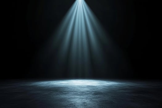 A spotlight shines on a dark floor photo