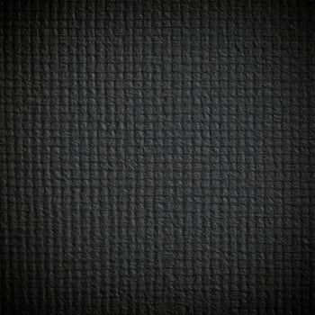 Close-up of a dark, gritty paper surface with textured patterns photo