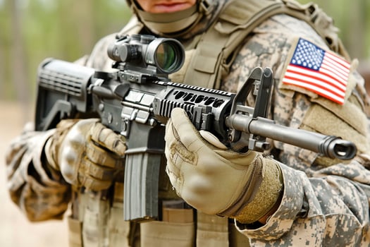 A soldier holding an american flag and an m16 rifle photo