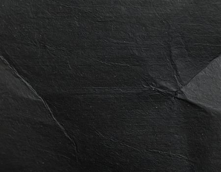 Close-up of a gritty black paper surface with textured pattern background photo