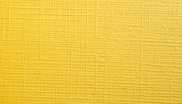 Close-up of a textured, yellow, coarse paper surface with visible patterning photo