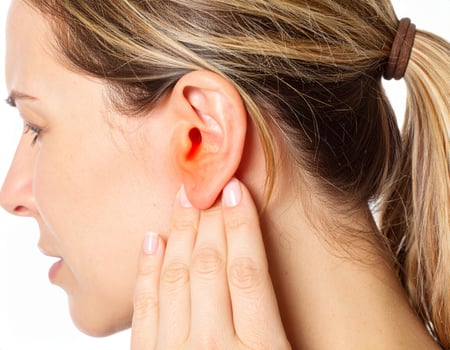 Illumined spot inside a semi-transparent head highlights nearby ear discomfort against a white backdrop. photo