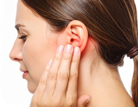 Illustration of ear discomfort spreading to surrounding regions, shown as a glowing spot inside a semi-transparent head on a white background. photo