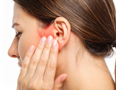 Highlighted area showing ear discomfort extending nearby, depicted as a glowing spot inside a semi-transparent head on a white backdrop photo