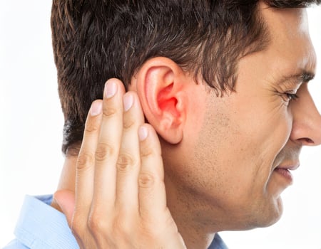 Illustration of earache causing nearby discomfort, shown as a glowing spot within a semi-transparent head on a white background. photo