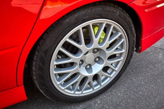 Modern red city car wheel close view photo