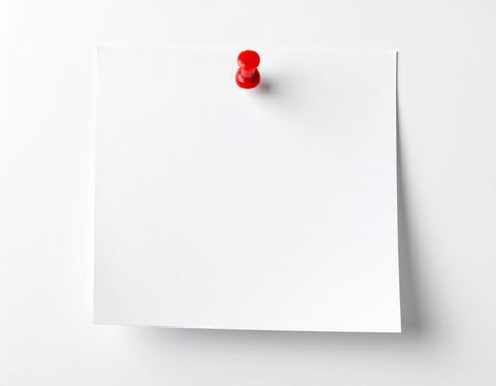 White sticky note attached with a pushpin on a plain white surface photo