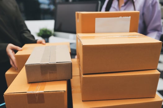 A man and woman are holding boxes in an office photo