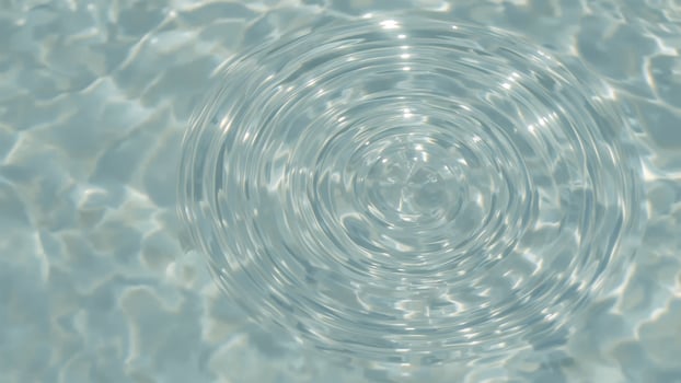 Close-up of water with splash droplets and circular ripples in the background photo