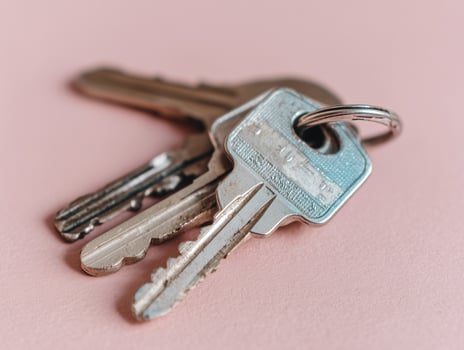 Three Metal Keys on Ring, Pink Background photo