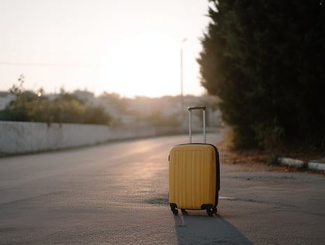 Yellow Suitcase on Asphalt Road at Sunset photo