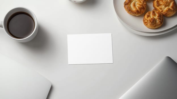 Blank business card on a white table with coffee and pastries photo