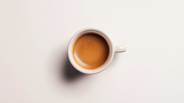 Overhead view of a white coffee cup filled with espresso photo