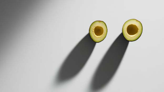 Two halved avocados, dramatic shadows photo