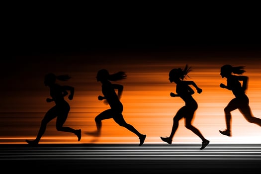 A group of women running in silhouette on an orange background photo