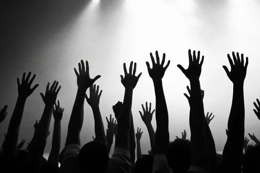 A crowd of people with their hands up in the air photo