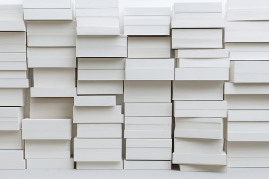 A large pile of white boxes stacked against a wall photo