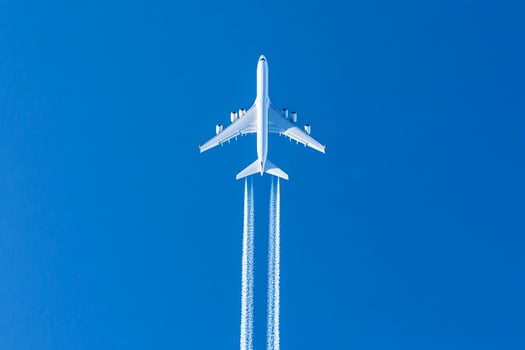 A large airplane flying through a blue sky photo