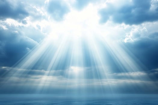 A bright sunbeam shines through the clouds over the ocean photo