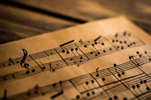 A sheet of music is laying on top of a wooden table photo