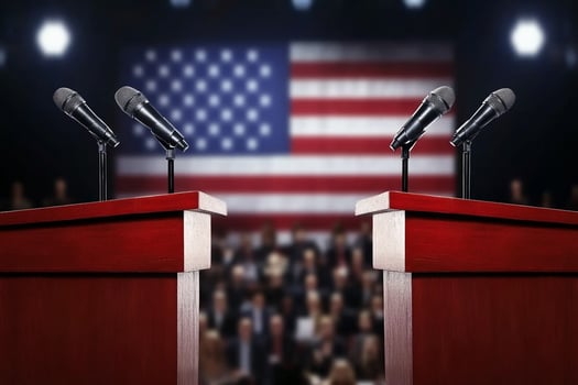 Two microphones on podiums in front of an american flag photo