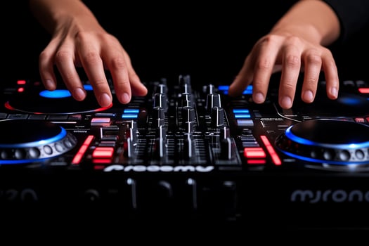 Hands on dj mixer with red and blue lights photo