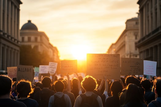 A group of people holding signs in the street at sunset photo