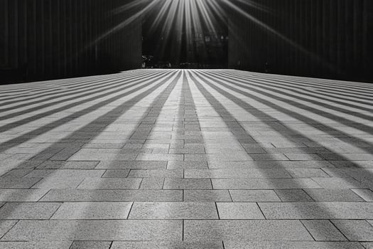 Sunbeams shining through the shadows of a large building photo