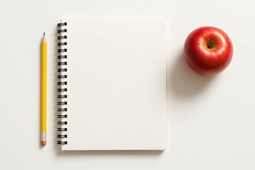 An apple and a blank notebook on a white background photo