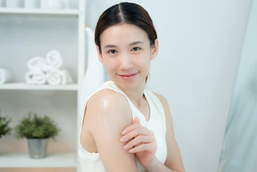 Beautiful Asian woman smile use cream for good skin. face of a healthy woman apply cream and makeup. Advertisement for skin cream, anti-wrinkle, baby face, whitening, moisturize tighten pores serum,. photo