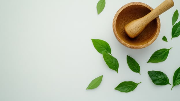 Wooden mortar and pestle with fresh leaves on a white background photo