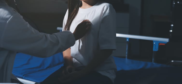 A woman is sitting in a hospital bed with a doctor photo