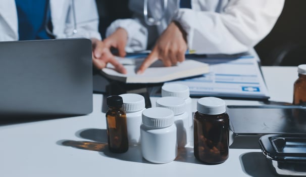 Two doctors working on a laptop and pills photo